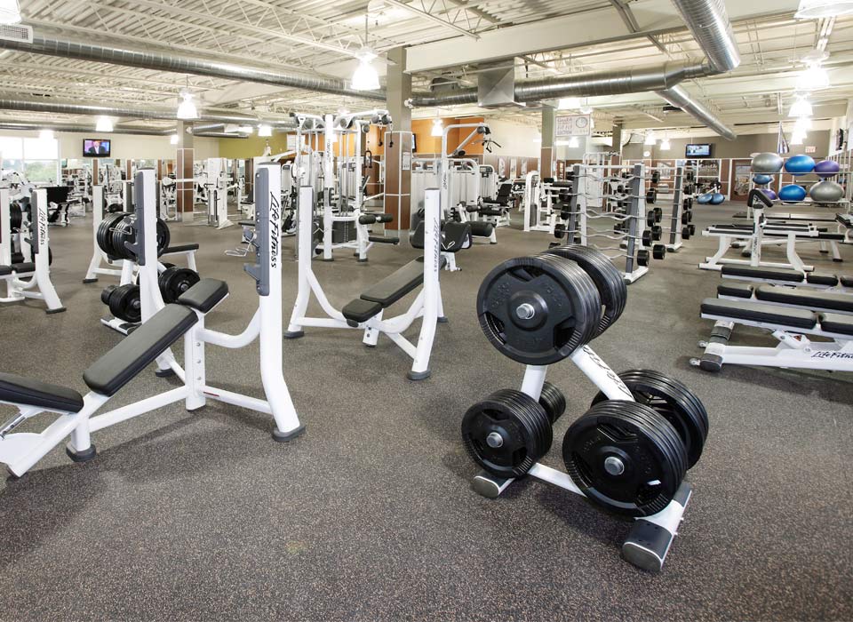 Commercial gym rubber flooring with dumbbell rack at a fitness centre in London Ontario