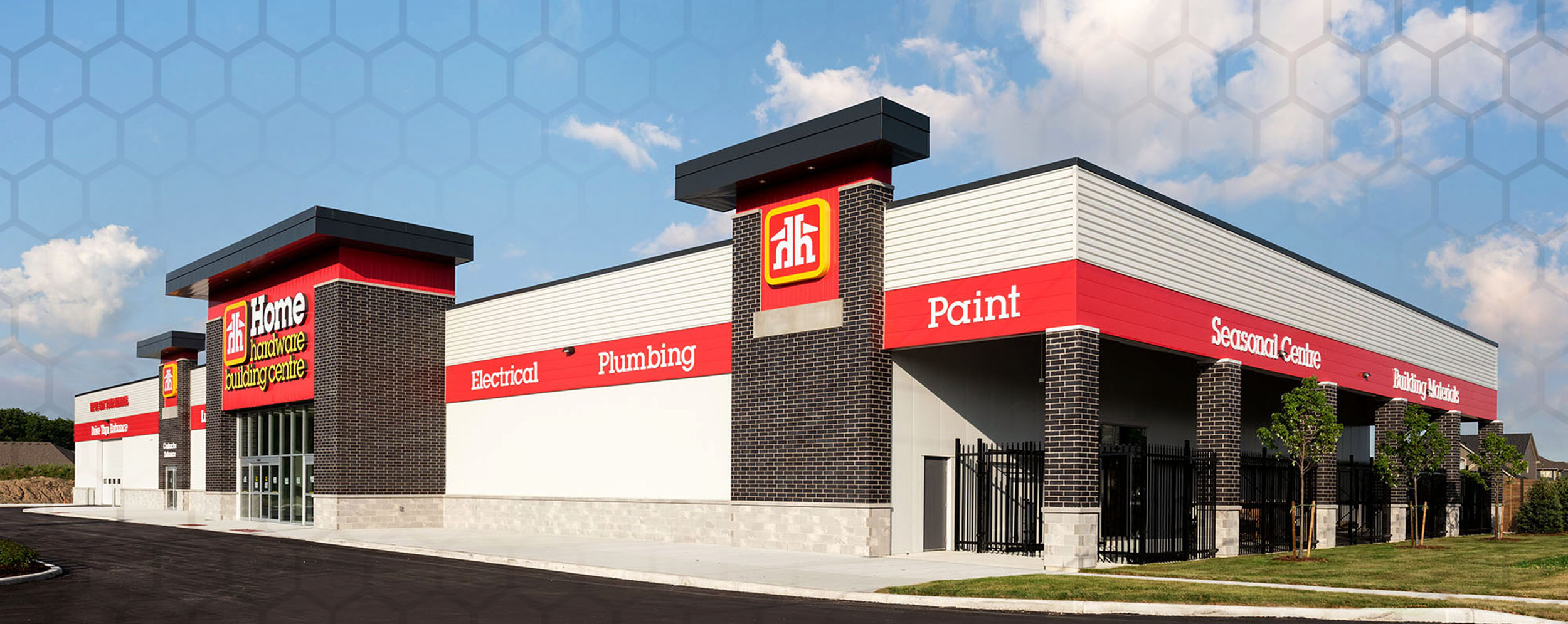 Home Hardware, Kilworth, Exterior photo of building, white facade, with dark columns and red accent with name.