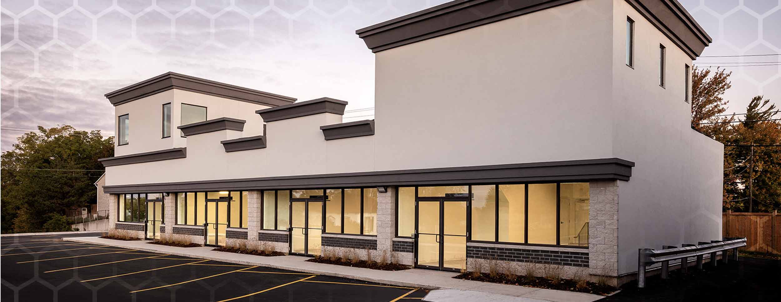 801 Dundas Street Woodstock Retail office building that has light beige walls and dark brown trim. Glass windows all across the first floor.