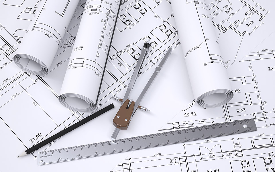 Engineering drawings for construction with a pencil, compass and ruler laying on top.