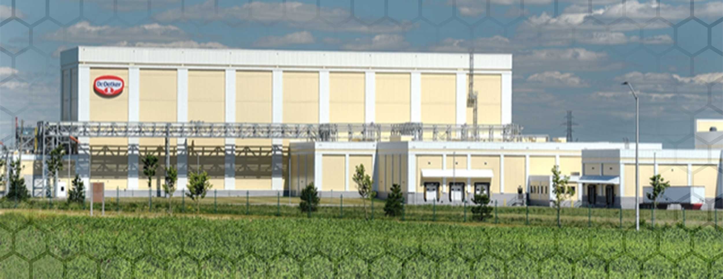 Dr. Oetker Facility, exterior photo showing the yellow building with white around the edges and strips of white top to bottom staggered along the building in the distance.