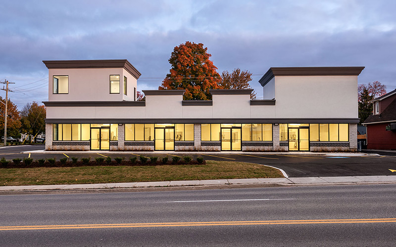 801 Dundas Street Woodstock Retail office building that has light beige walls and dark brown trim. Glass windows all across the first floor.