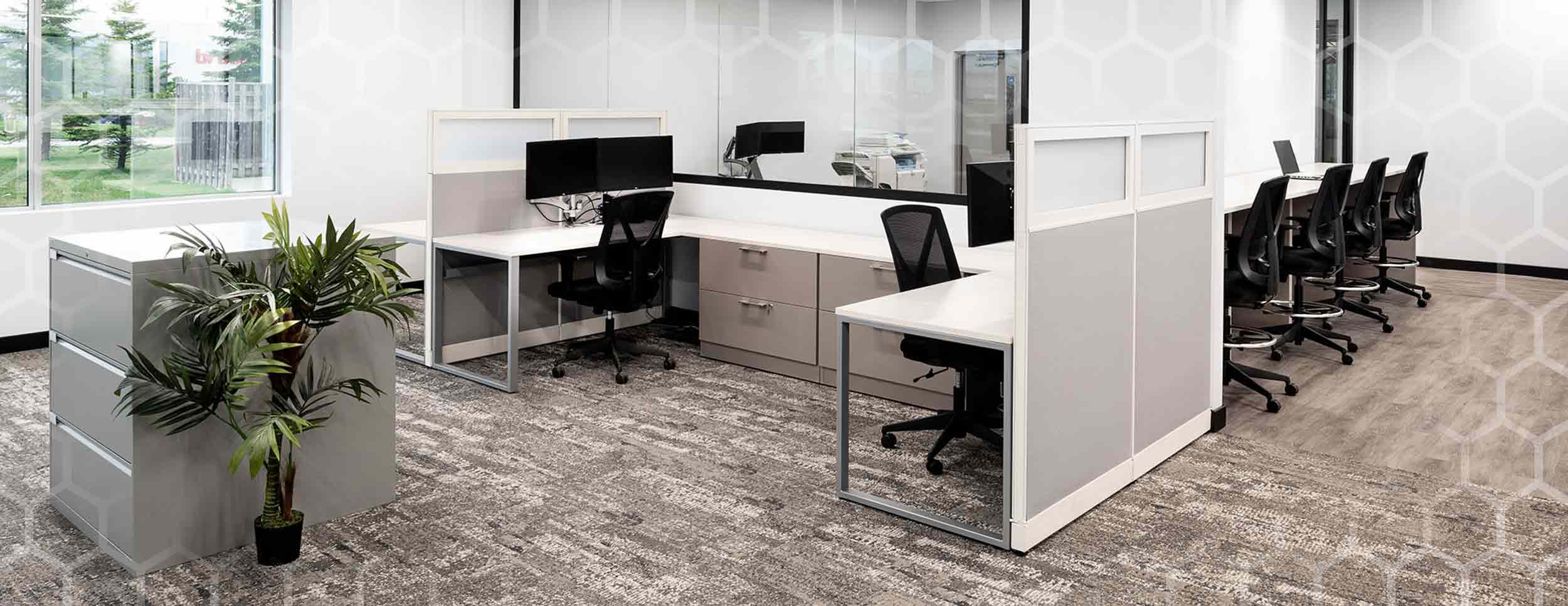 Interior Photo of Spark Power Office, White Walls, Big Glass Window in the middle of the wall directly in the center of the photo, 2 cubicles to either side of the window with multicolored grey carpet.