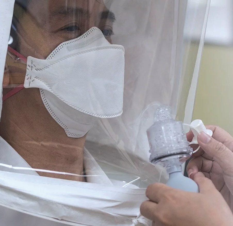 A Mosaic Medical staff member performing mask fitting on a client.