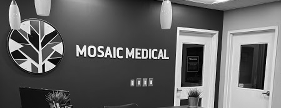 Reception area of a medical office with a logo of a stylized tree, the words "Mosaic Medical," modern decor, pendant lights, and potted plants.