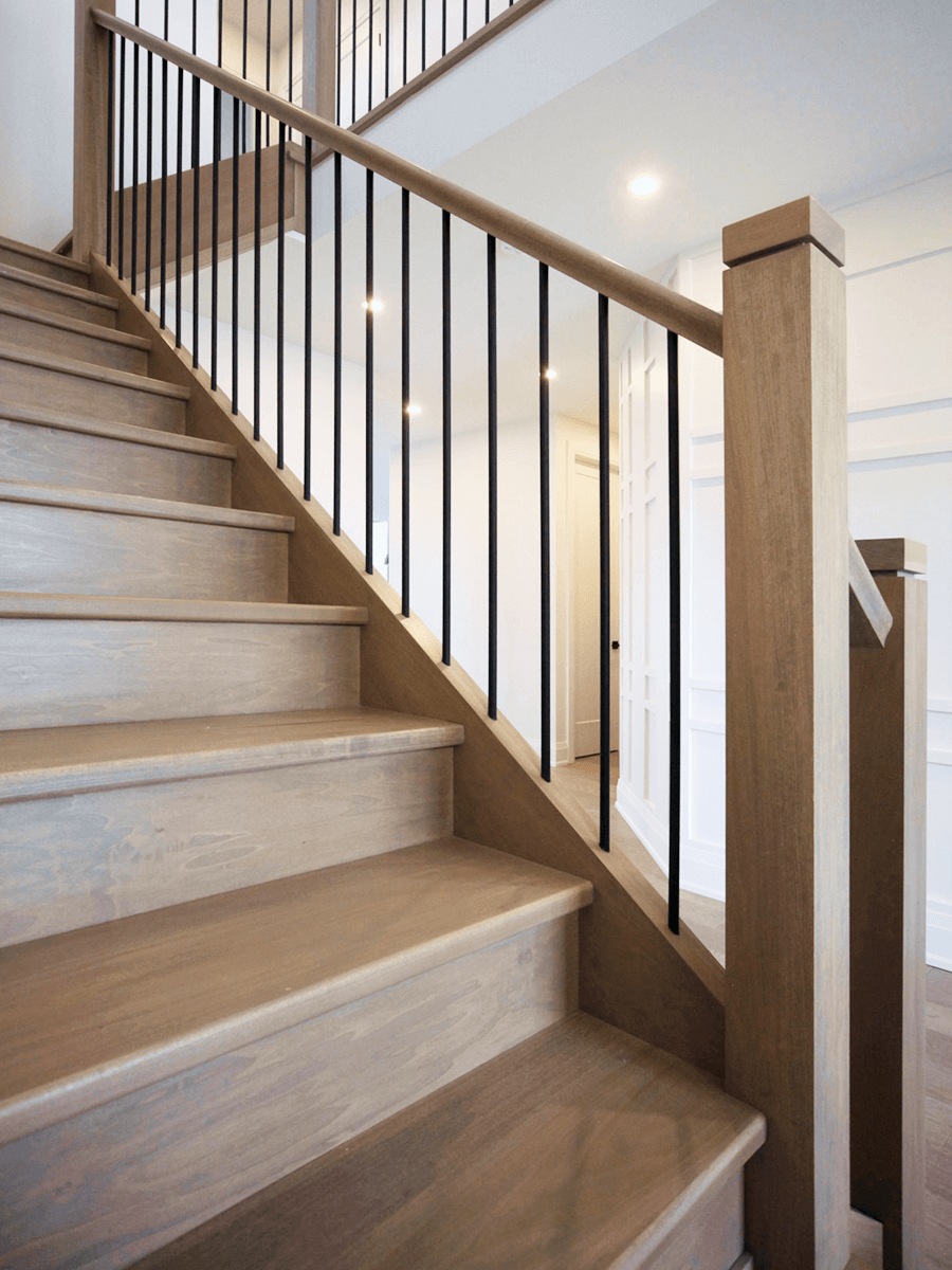 Custom oak stair posts and matte black railings in interiors across Oakville, London, and Burlington